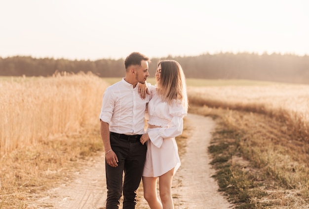 Um jovem casal homem e mulher se abraçam com ternura na natureza no verão. amantes