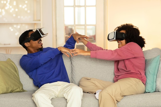 Um jovem casal negro a experimentar simulações VR divertidas e interactivas dentro de casa.