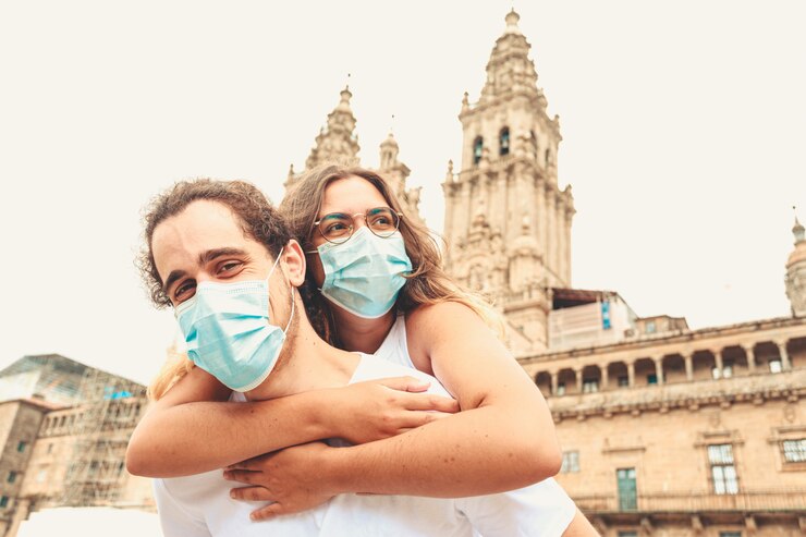 Foto um jovem casal se divertindo durante a viagem com as máscaras colocadas
