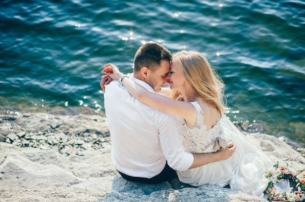 Um jovem casal sentado na praia