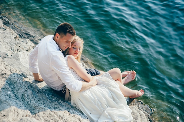 um jovem casal sentado na praia
