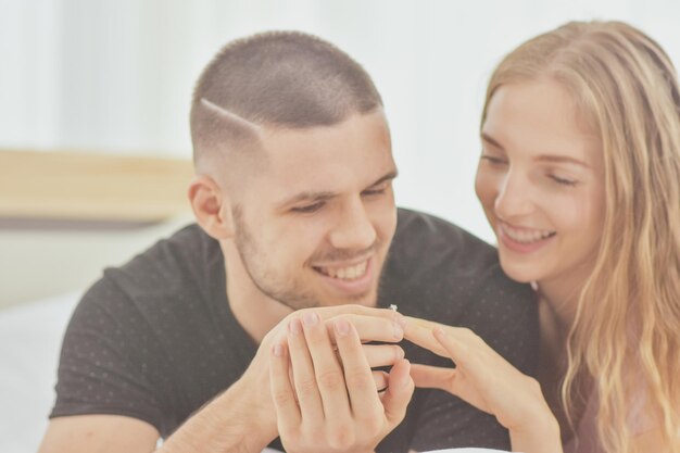 Foto um jovem casal sorridente com anel de noivado.