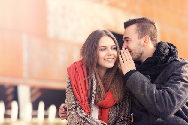 um jovem casal sussurrando em um dia de outono