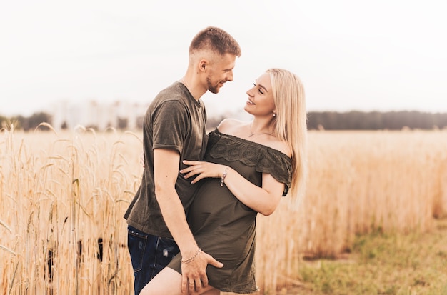 Um jovem casal, um homem e uma mulher se olham com amor no verão na natureza