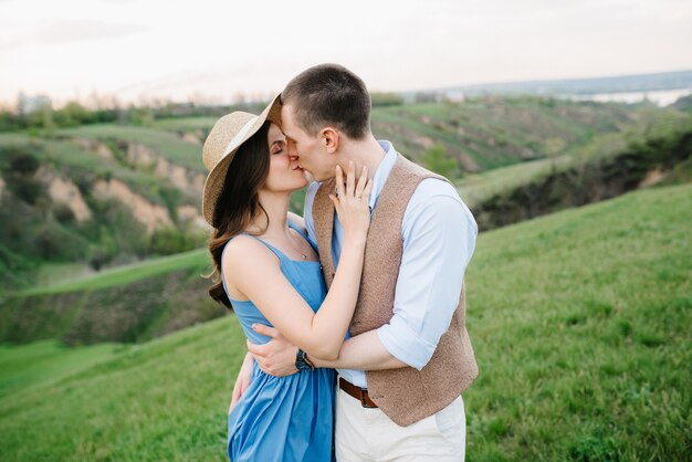 Um jovem casal, um rapaz e uma rapariga, está a caminhar nas verdes colinas de montanha