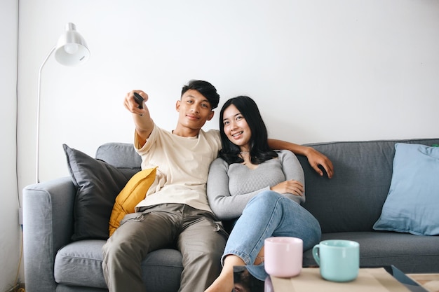 Um jovem casal vendo televisão juntos em casa