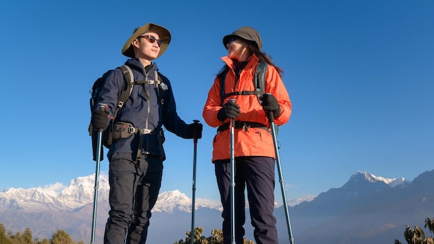 Um jovem casal viajando no ponto de vista de Poon Hill em Ghorepani Nepalx9