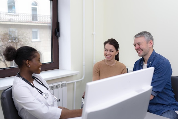 Foto um jovem casal visitando um médico em uma clínica de planejamento familiar