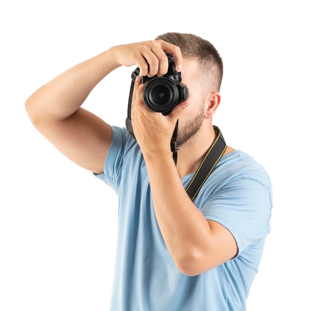 Um jovem com uma câmera preta isolada em um fundo branco perfeito tirando uma foto vertical