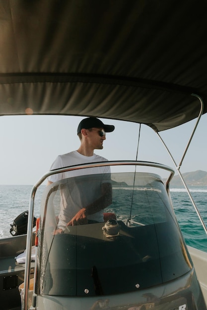 Um jovem controla um barco no mar