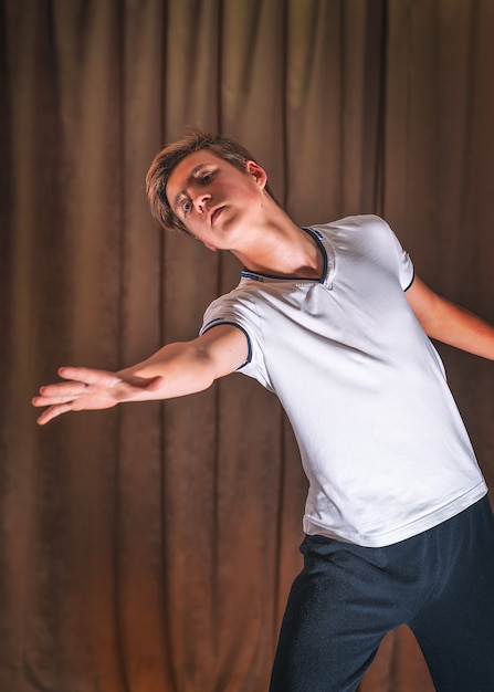 Foto um jovem dançarino ensaiando no palco, os elementos da dança.