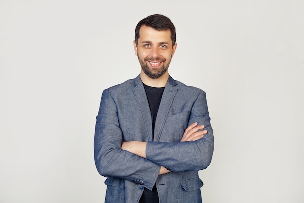 Um jovem de barba sorrindo com uma cara feliz, olhando e apontando para o lado com o polegar para um local de publicidade, olhe aqui,