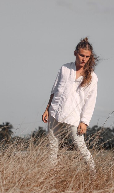 Um jovem de suéter branco gosta da natureza