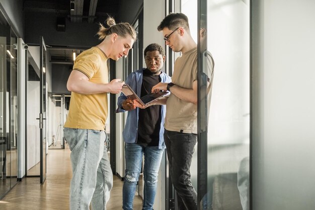 Um jovem desenvolvedor atribui novas tarefas de projeto a seus parceiros, empresários estão discutindo um novo negócio