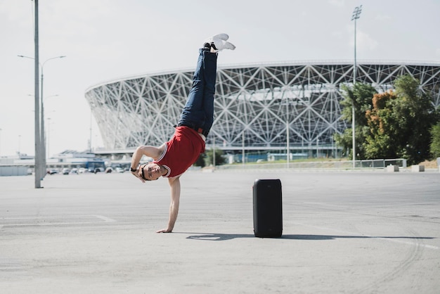 Um jovem do sexo masculino em movimento acrobático livre na rua da cidade, belo exercício físico