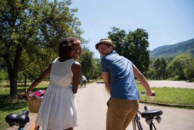 um jovem e uma linda garota afro-americana desfrutando de um passeio de bicicleta na natureza em um dia ensolarado de verão