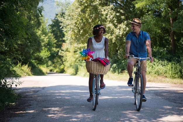 um jovem e uma linda garota afro-americana desfrutando de um passeio de bicicleta na natureza em um dia ensolarado de verão