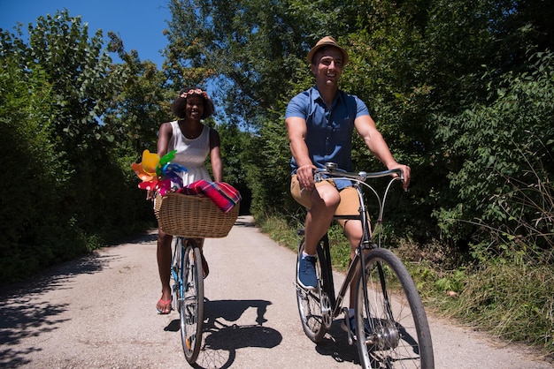 um jovem e uma linda garota afro-americana desfrutando de um passeio de bicicleta na natureza em um dia ensolarado de verão