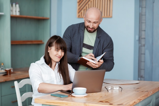 Um jovem e uma mulher trabalham em casa usando um laptop