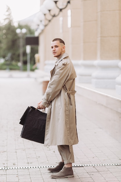 Um jovem elegante com sacos depois de fazer compras bem sucedidas na Black Friday