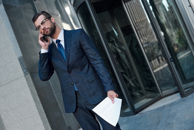 Um jovem empresário de óculos e barba fica chateado com um acordo fracassado