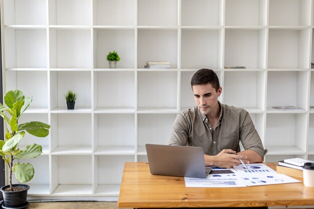 Um jovem empresário está discutindo uma videoconferência com laptop com um parceiro de negócios que fundou uma empresa iniciante juntos. Eles têm uma reunião de finanças da empresa para consertar e planejar acordos financeiros.