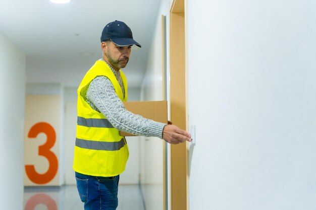 Um jovem entregador com uniforme de proteção na entrega do pedido online na entrega em domicílio