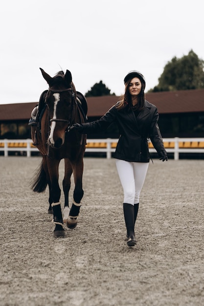 Um jovem equestre de uniforme posa com uma bela foto de alta qualidade de cavalo majestoso