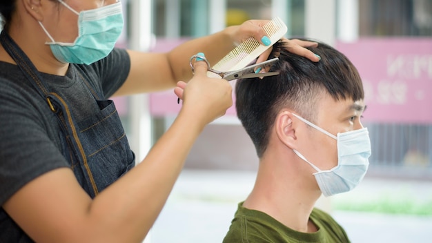 Um jovem está cortando o cabelo em um salão de cabeleireiro