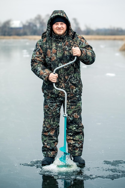 Um jovem está pescando de um buraco no gelo pesca de inverno