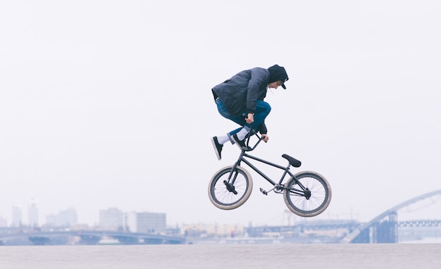 Um jovem faz um truque de navio de cruzeiro no ar em uma bicicleta de BMX.