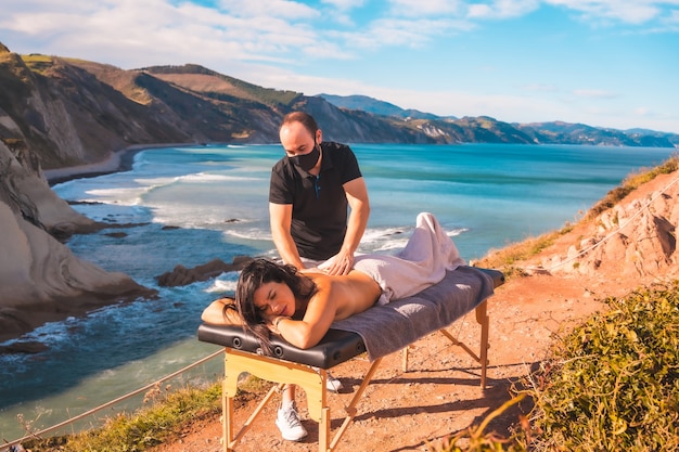 Um jovem fazendo uma massagem natural na costa perto do mar, um sonho tornado realidade