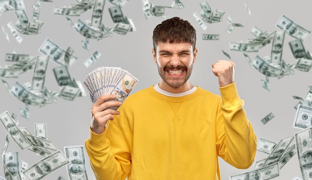 Um jovem feliz com dinheiro a celebrar o sucesso.