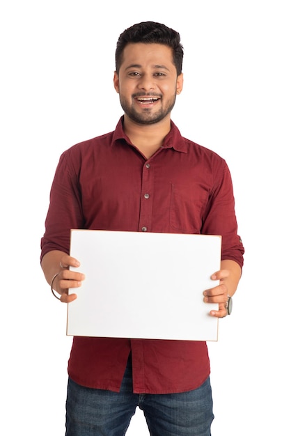 Um jovem feliz segurando e exibindo uma placa ou cartaz nas mãos em um fundo branco