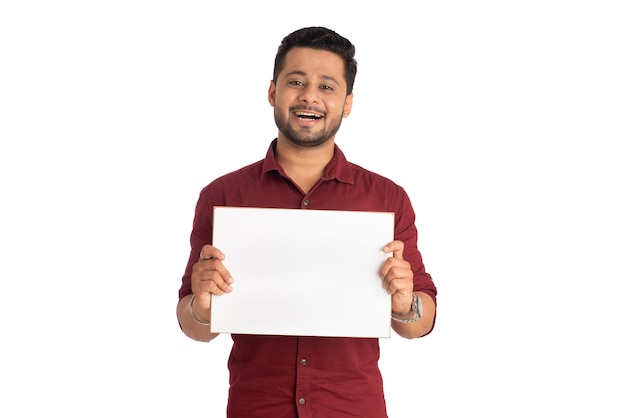 Um jovem feliz segurando e exibindo uma placa ou cartaz nas mãos em um fundo branco