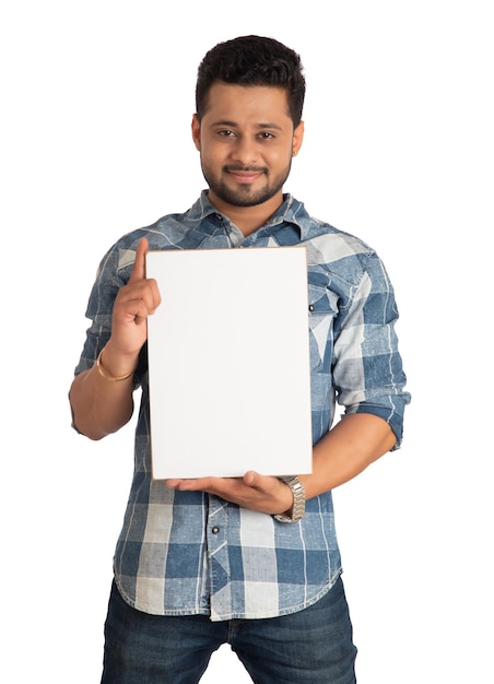 Foto um jovem feliz segurando e exibindo uma placa ou cartaz nas mãos em um fundo branco