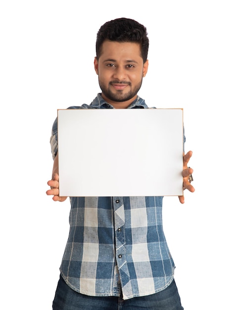 Foto um jovem feliz segurando e exibindo uma placa ou cartaz nas mãos em um fundo branco
