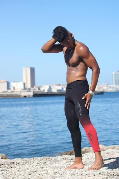 Um jovem fitness cubano na costa