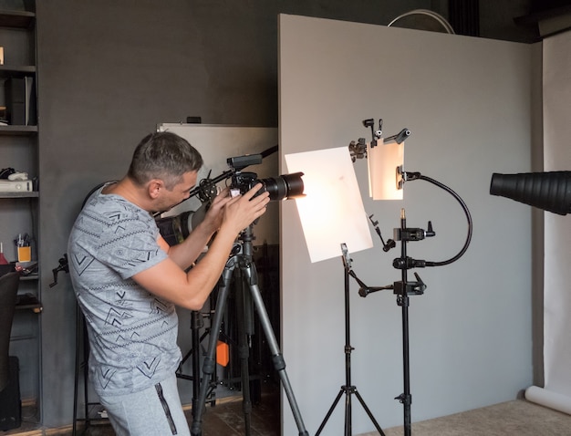 Um jovem fotógrafo trabalha em um estúdio fotográfico. fotografia não intencional