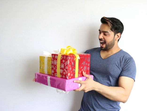 Um jovem indiano segurando uma caixa de presente, natal, dia dos namorados, aniversário, conceito de felicidade