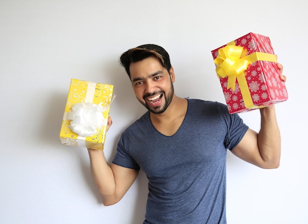 Um jovem indiano segurando uma caixa de presente, natal, dia dos namorados, aniversário, conceito de felicidade