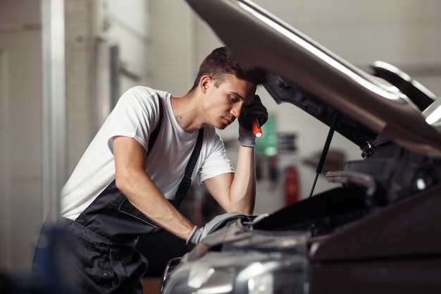 Um jovem mecânico fica intrigado enquanto trabalhava em um serviço e manutenção de automóveis.