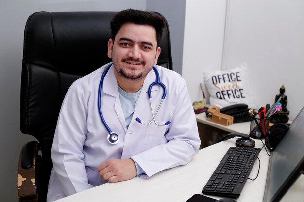 Um jovem médico está sentado na clínica e sorrindo