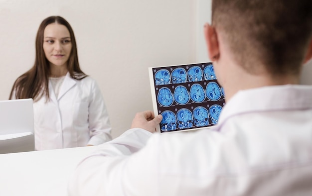 Um jovem médico olha para uma imagem de raio X de uma tomografia computadorizada na recepção do hospital