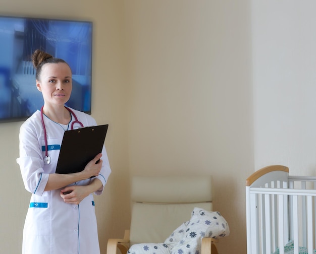 Um jovem médico sorridente com um uniforme profissional em uma enfermaria pós-parto.