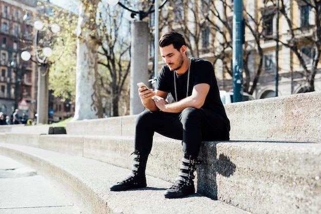 Um jovem menino italiano usando um smartphone