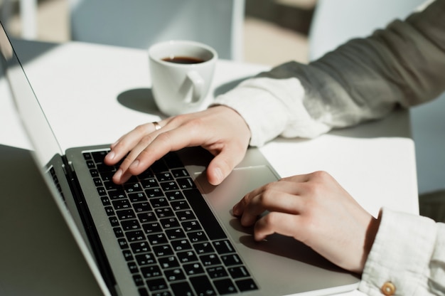 Um jovem millennial masculino trabalha remotamente em um laptop.