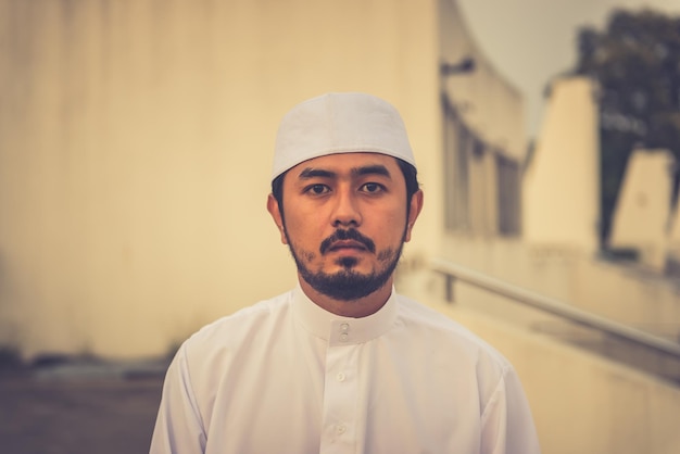 Um jovem muçulmano asiático rezando no conceito de festival do pôr do sol do Ramadã