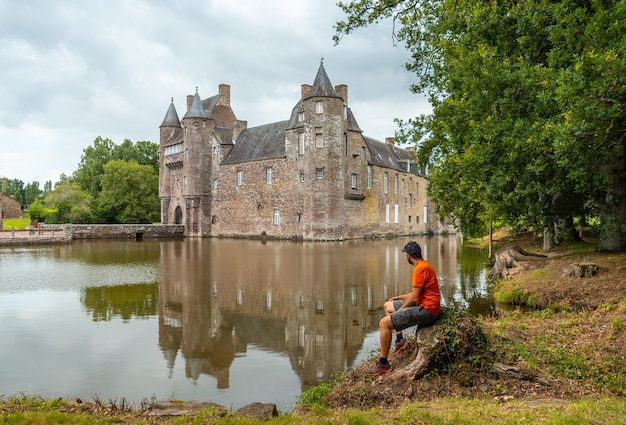 Um jovem no castelo medieval à beira do lago Trecesson, comuna de CampÃƒÂƒÃ‚Â © nÃƒÂƒÃ‚Â © ac no departamento de Morbihan, perto da floresta de Broceliande.