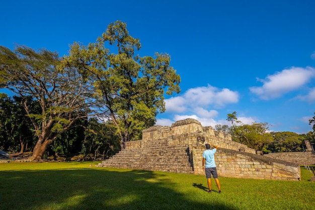 Um jovem olhando para uma pirâmide nos templos de Copan Ruinas Honduras